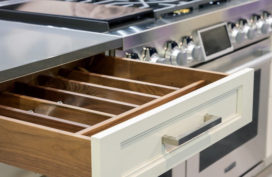 Glass-front upper cabinets with interior lighting in a finished kitchen